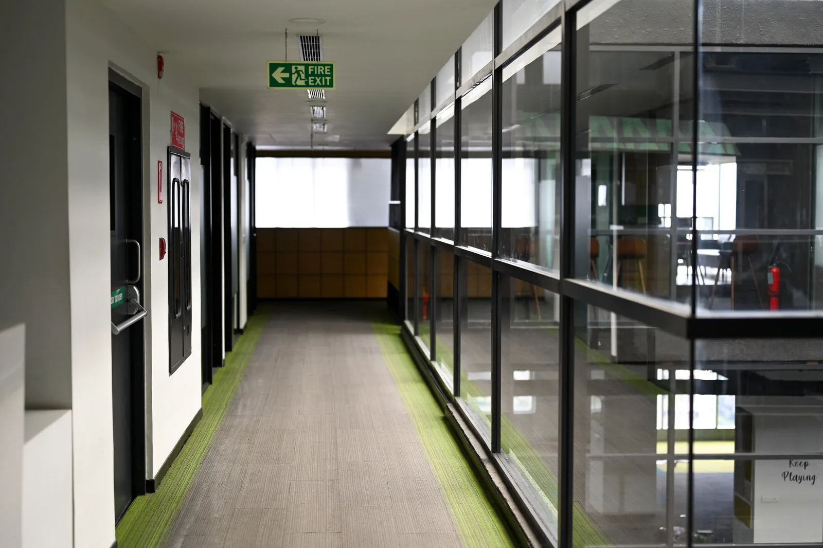 Glass-walled hallway leading to The Yard coworking space in Bellandur