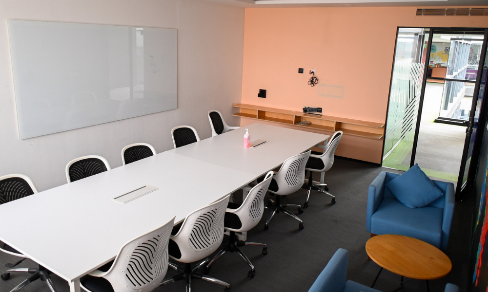 Modern meeting room setup for client meetings in coworking space with table, chairs, and whiteboard