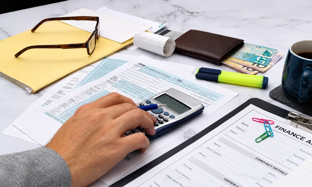 Calculating income tax return with tax form and calculator for coworking expense deductions