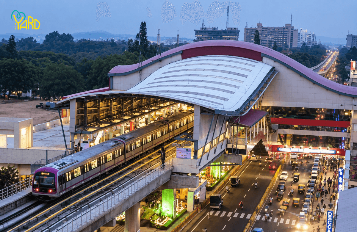 Namma Metro train arriving at a Bangalore metro station near heavy traffic