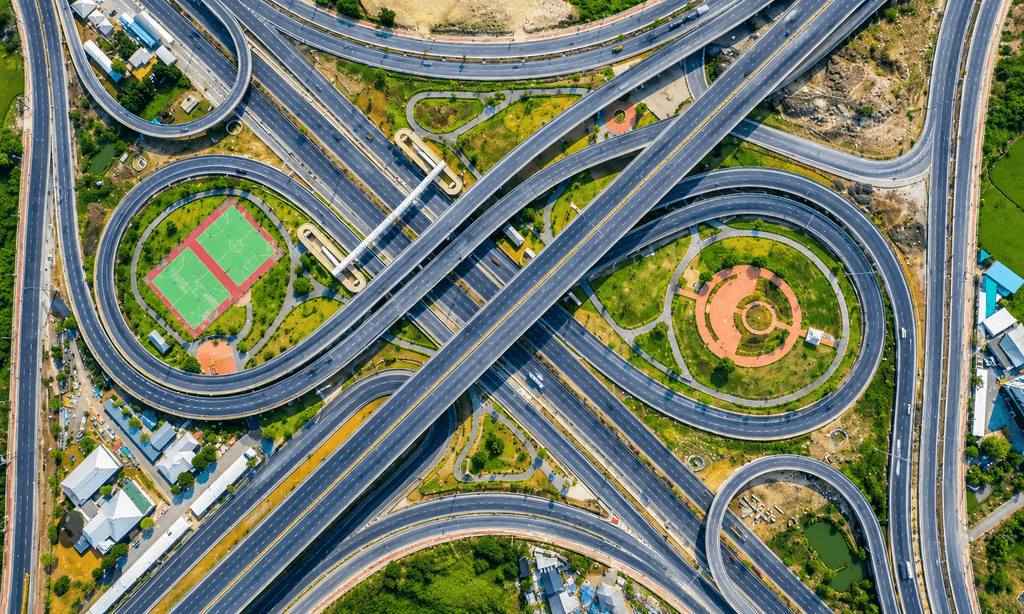 Aerial view of a highway flyover interchange representing Bangalore's expanding road network