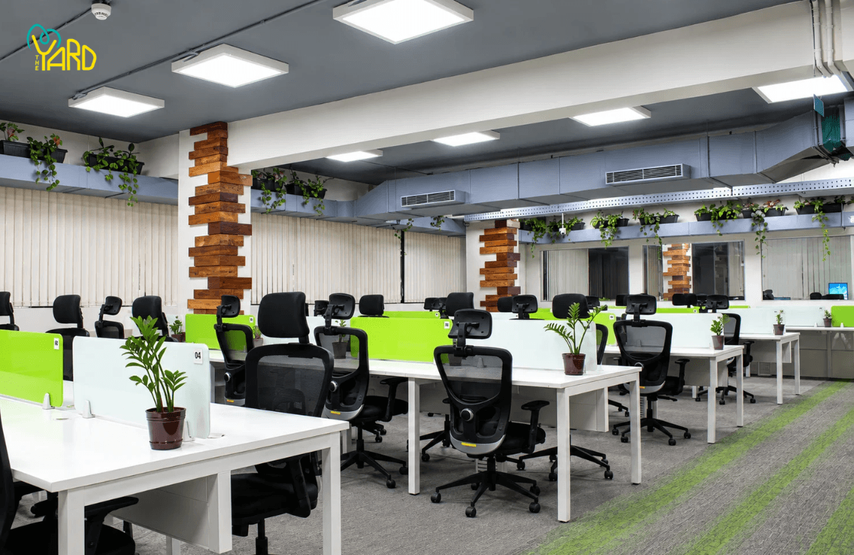 The Yard coworking space in Bangalore with shared office desks, ergonomic chairs, and green desk partitions