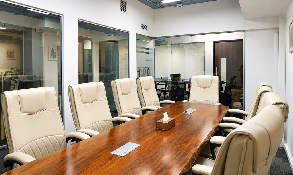 The Yard coworking space in Bengaluru with a wooden meeting table, green chairs and a modern collaborative lounge